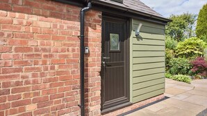 A brick building with a dark green door and a window. - Host & Stay | Garden Studio (Hartlebury)