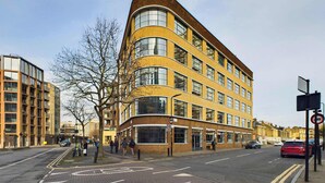 A multi-story building with a curved facade, large windows, and a brick exterior. - Spacious and Bright Apartment by Tech City (Greater London)