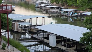 A marina with multiple docked boats and covered structures.