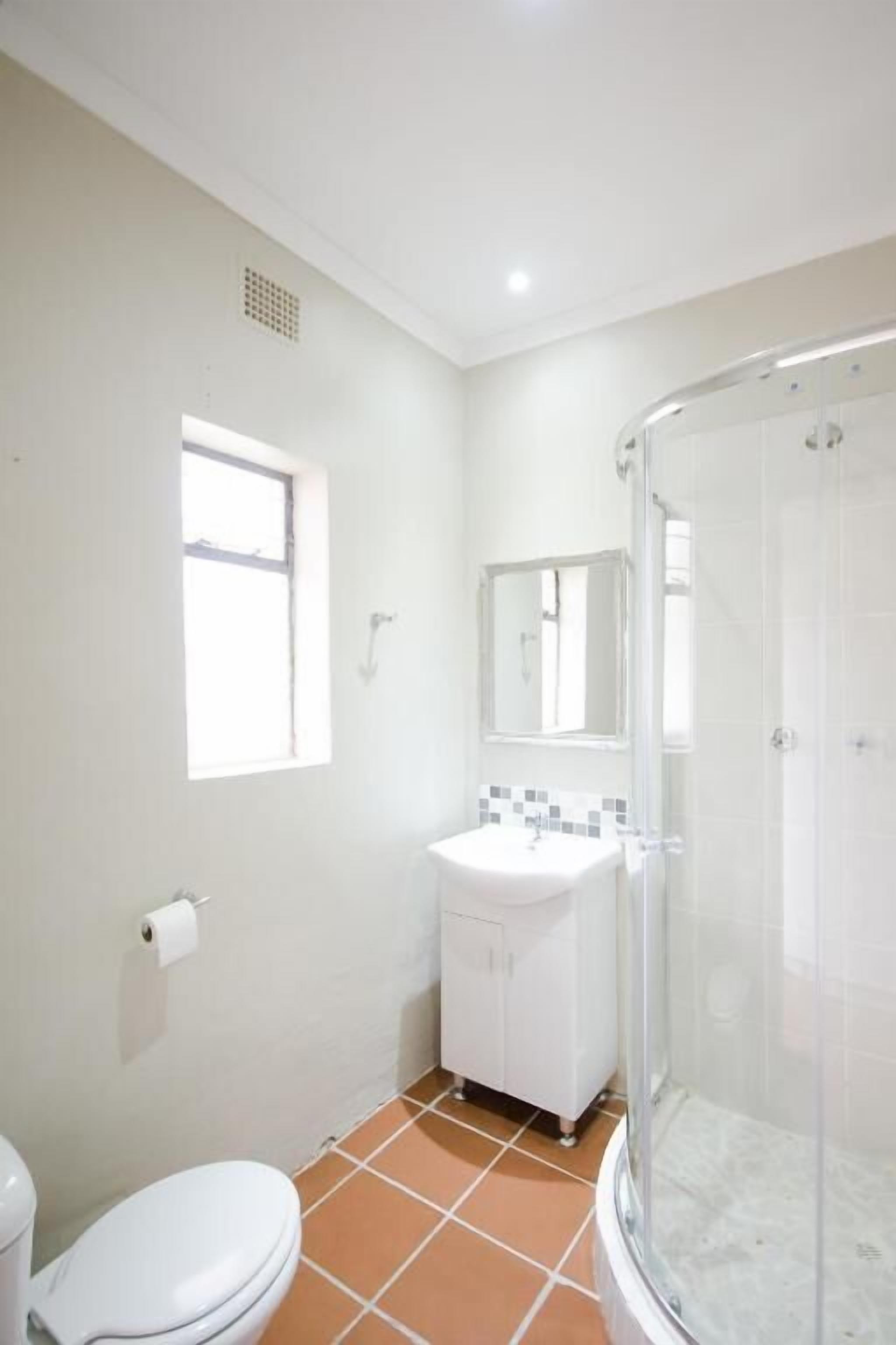 Un baño con inodoro, lavabo y ducha.