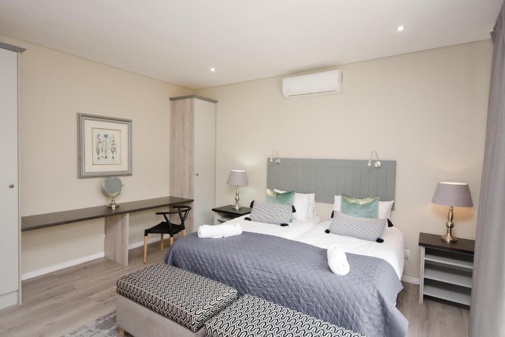 A hotel room with a large bed, bedside tables, a desk, and a chair.