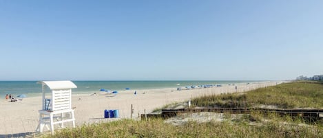 Enjoy a safe and protected beach experience with designated sun shelters and a lifeguard tower.
