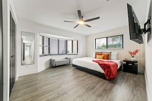 This spacious master bedroom also features cozy little couch offers a relaxing spot to unwind, while a large window fills the room with natural light. The room also includes a full-body mirror for convenience