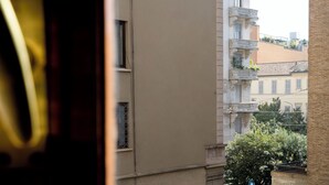Vista de un edificio con varios balcones y una ventana con celosía de metal.
