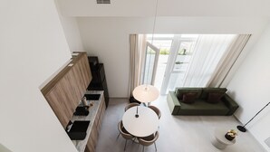 Een moderne keuken met een zithoek, een bank en een kleine tafel met een plant.
