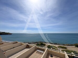 A balcony with a view of the sea and a clear sky.