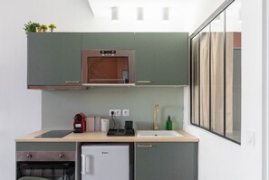 A compact kitchen with a built-in oven, a sink, and a small refrigerator. - Vieux-Port/Gare St Charles Le Ramsès (6pers) (Marseille)