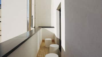 A narrow hallway with a black countertop and three white stools.