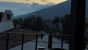 Vista de una cordillera al atardecer, con un edificio en primer plano.