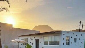 A modern white building with a flat roof, large windows, and a unique geometric facade. - Charming Rural House (Arona)