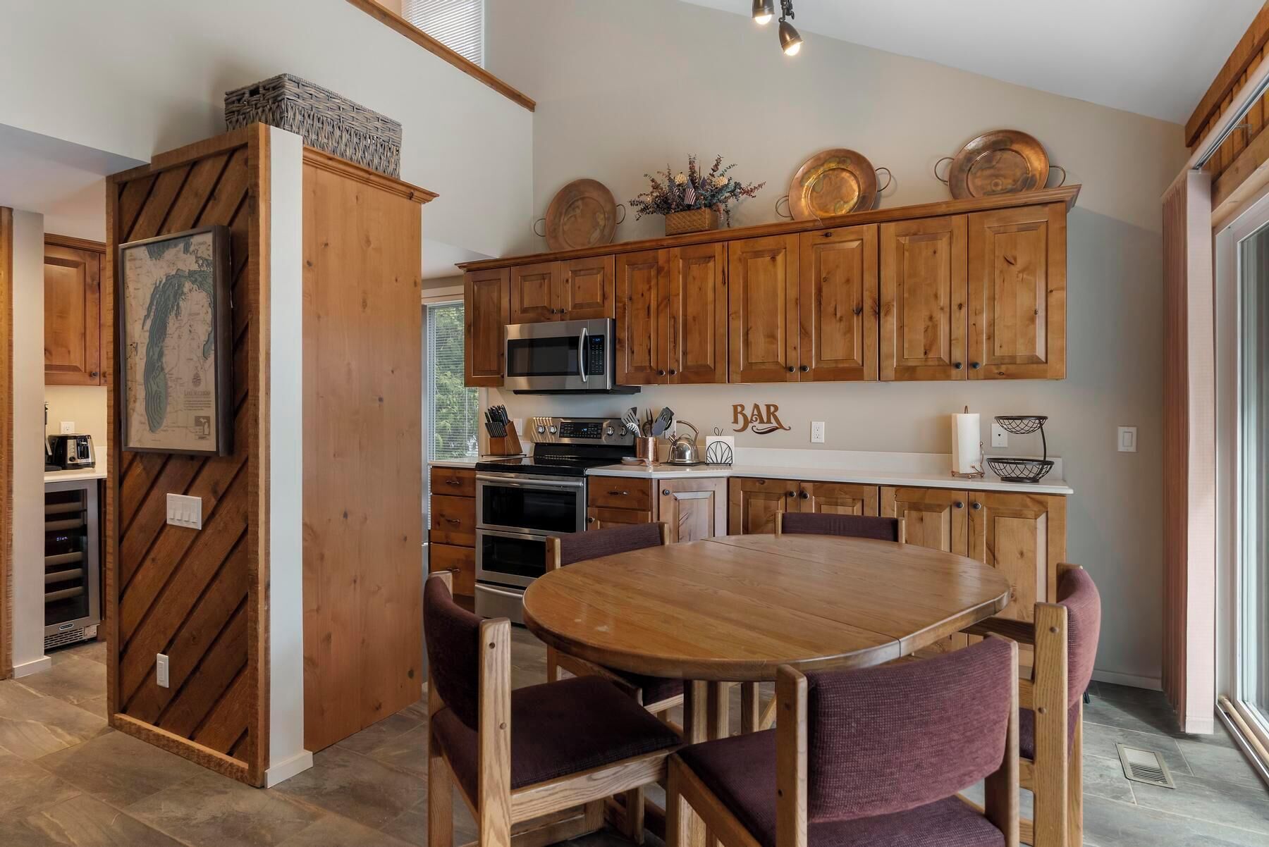 Une cuisine dotée de meubles en bois, d’un four à micro-ondes et d’un coin repas avec une table ronde et des chaises.
