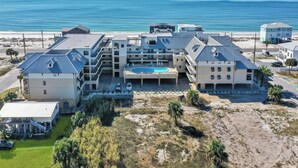 Un hôtel situé en bord de mer, composé de plusieurs bâtiments, doté d’une piscine et offrant une vue sur l’océan.