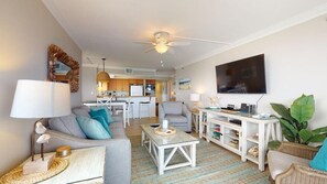 A modern living room with a sofa, coffee table, and a dining area with chairs.