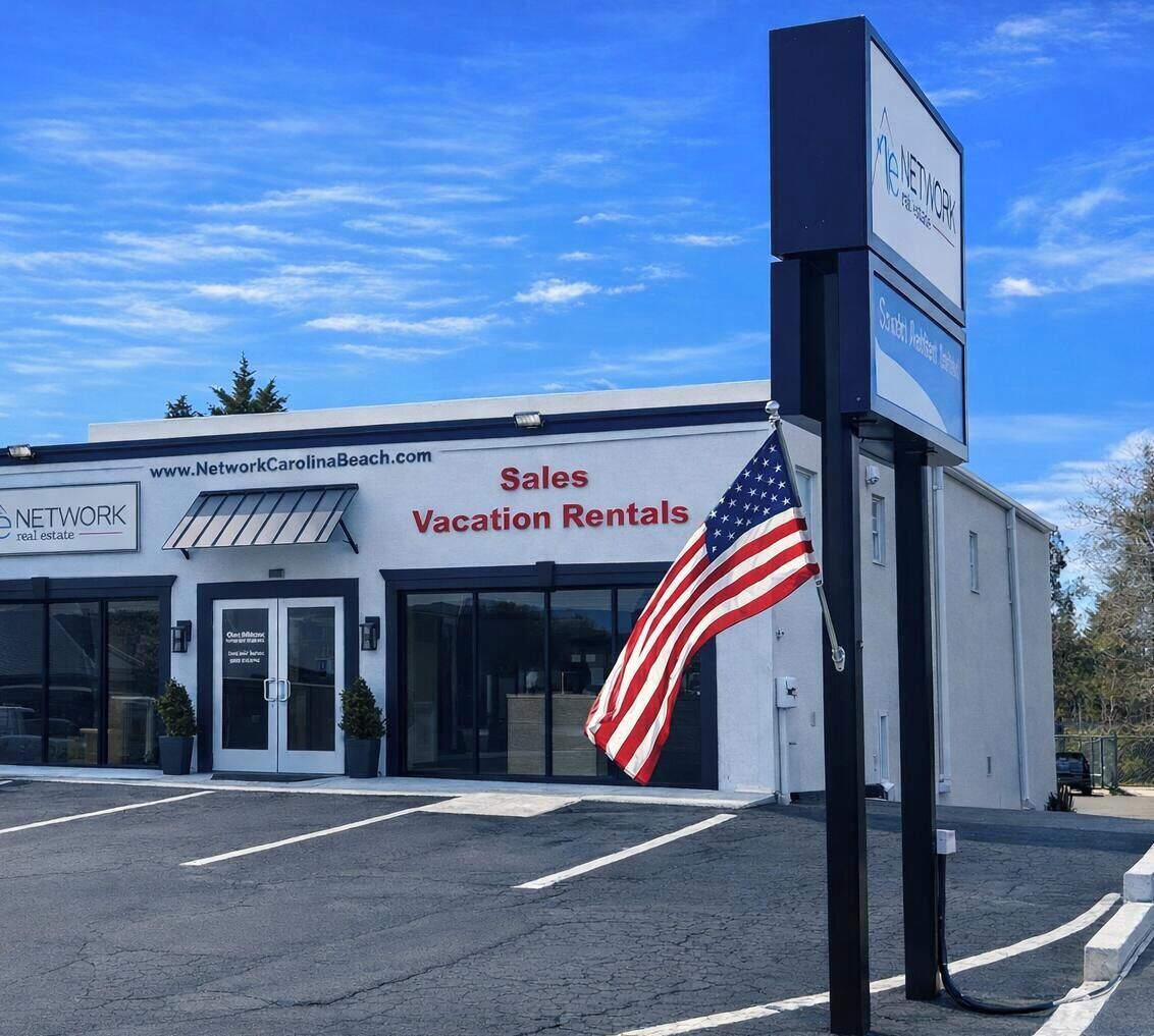 A building with a sign for 'Sales Vacation Rentals' and an American flag.