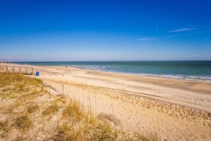 A beach with a wooden walkway and a clear blue sky. - Pelican Watch 406-Beautiful 4th Floor 3 bedroom freshly painted with new furniture and elevators. (Carolina Beach)