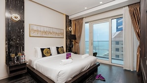 A modern hotel room with a large bed, a view of the city, and a balcony. - High End Luxury Stay with Full Palm Jumeirah View (Dubai)