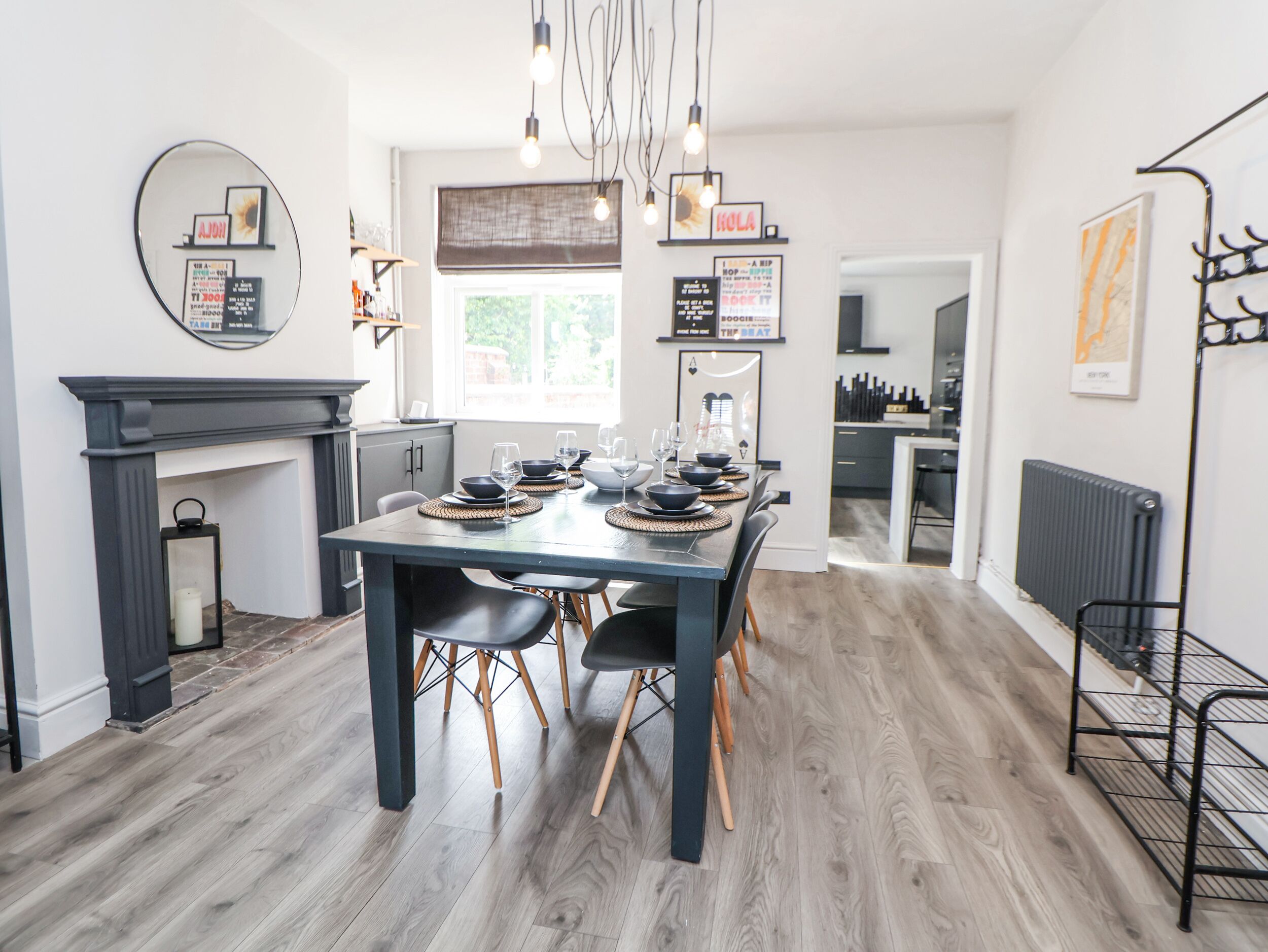Una cocina moderna con una mesa de comedor para seis personas, sillas de madera y una decoración en blanco y negro.