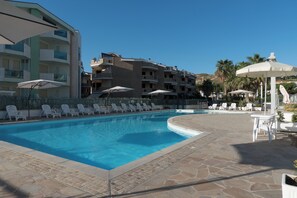 A swimming pool with lounge chairs and umbrellas, surrounded by multi-story buildings with balconies. - Residence Roseto Pool Seaview Abruzzo (Roseto degli Abruzzi)