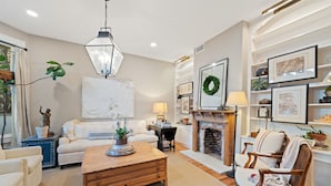 A cozy living room with a fireplace, a sofa, a coffee table, and a bookshelf. - Perfect 4 Families, Mins 2 Beach, Amazing Backyard (Ventura)
