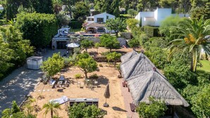 A resort with a pool, outdoor seating, and a large house.