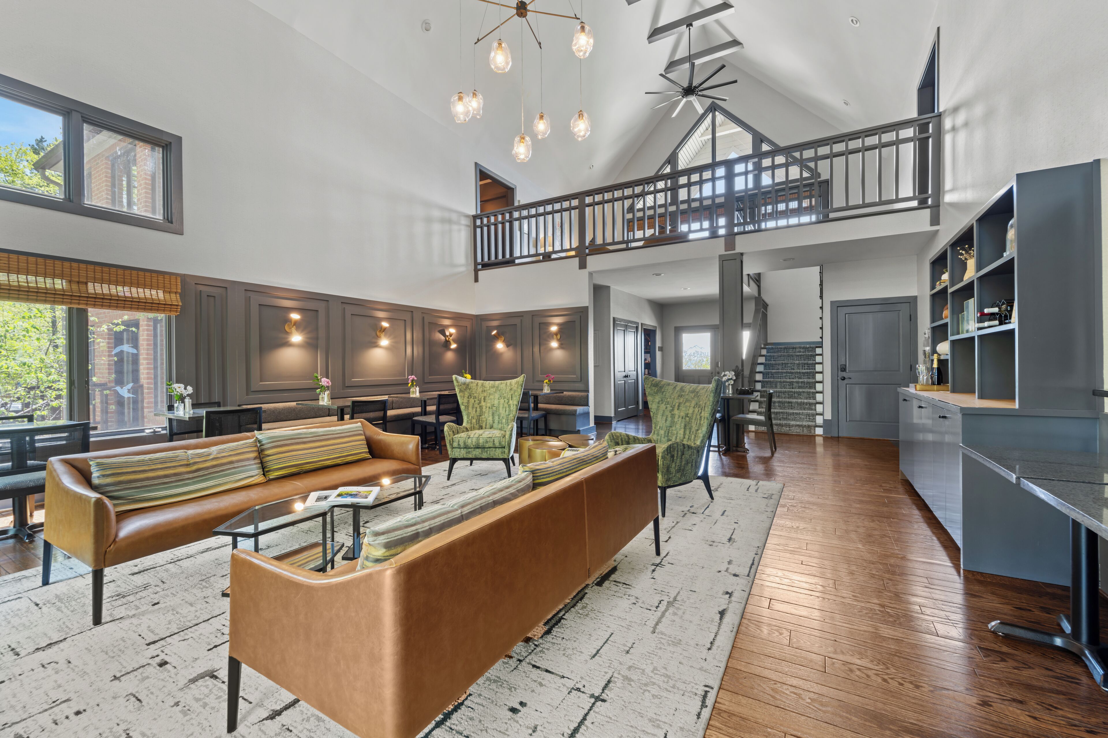 A spacious living area with a high ceiling, a built-in bench, and a staircase leading to an upper level.