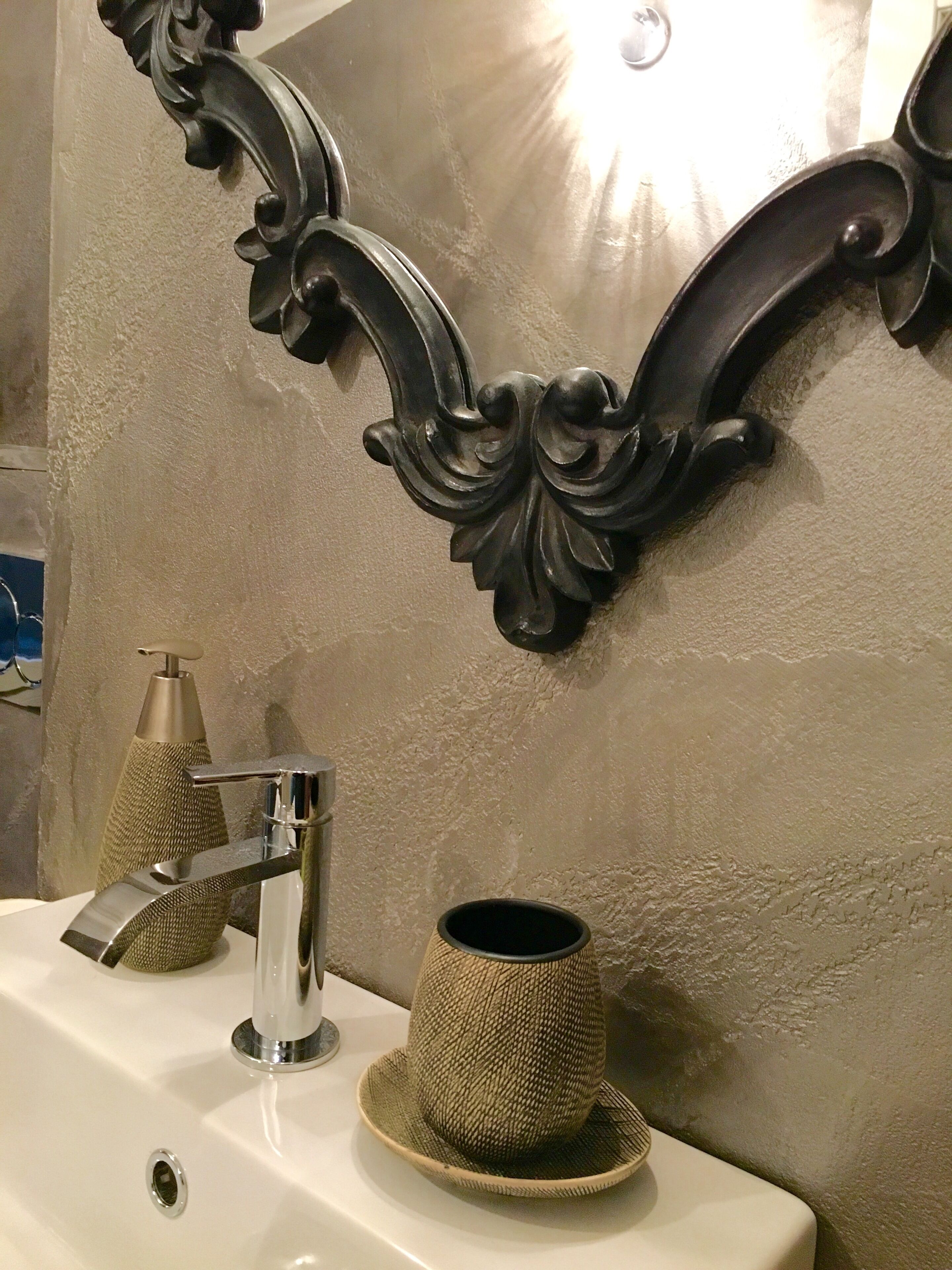 Ein Badezimmer mit Waschbecken, Spiegel und einer Wanddekoration.