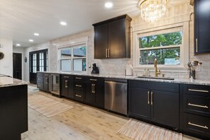 Enjoy cooking in this well-equipped kitchen with a stainless steel dishwasher, granite countertop, and ample natural light.