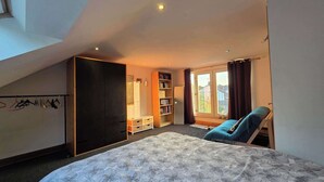 A bedroom with a bed, a wardrobe, a bookshelf, a desk, and a window with curtains. - Peaceful 3BDR Retreat by Epping Forest Chingford (Greater London)