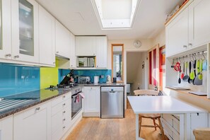A modern kitchen with white cabinets, a stainless steel dishwasher, a microwave, and a toaster.