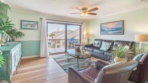 A living room with a sofa, chairs, a coffee table, a ceiling fan, and a view through a sliding glass door to the outside. - 🐾️Pet Friendly ~ Beach View - Pool ~ Blue Surf 17B☀️ (Miramar Beach)