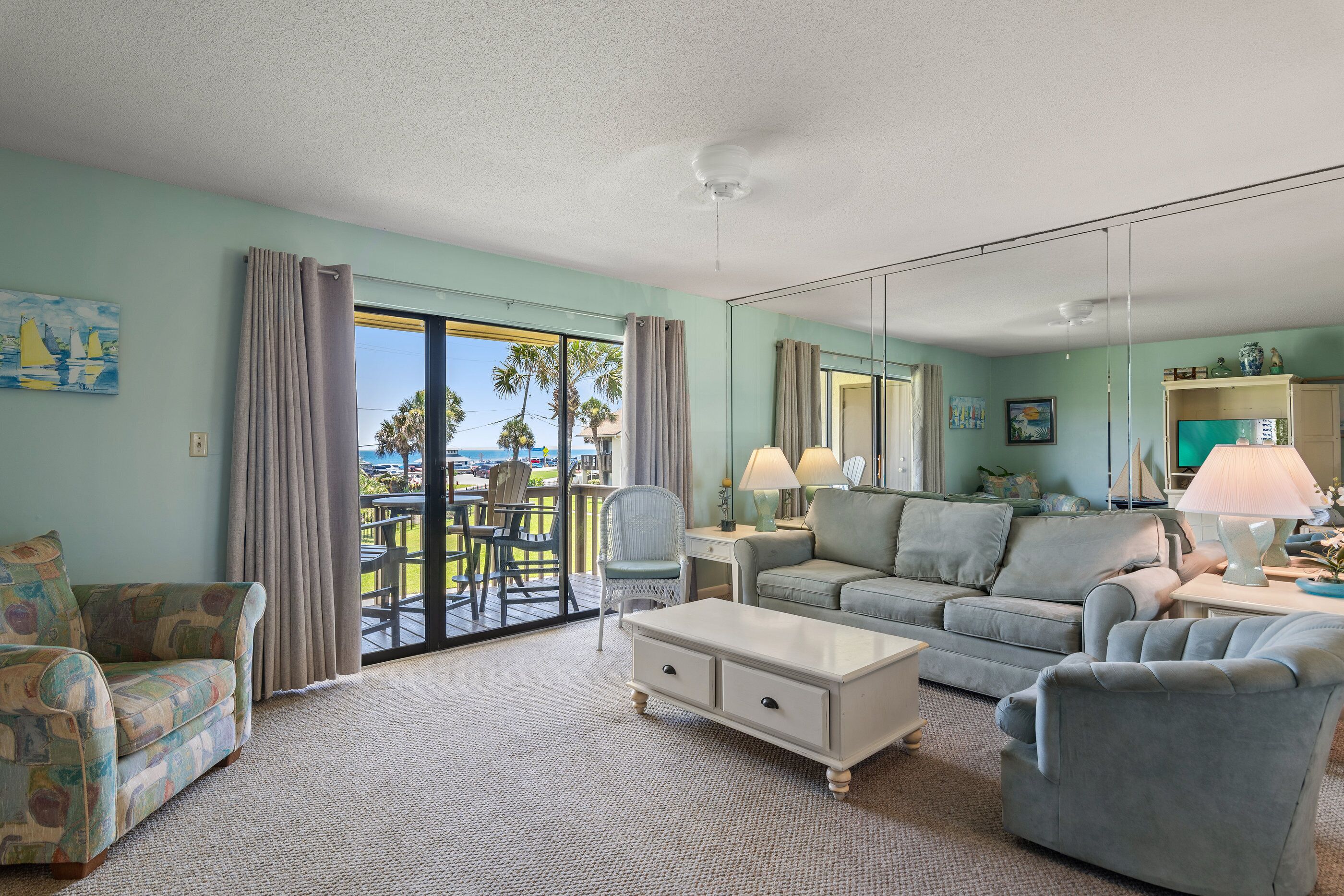 A living room with a large window, a sofa, a coffee table, and a chair.