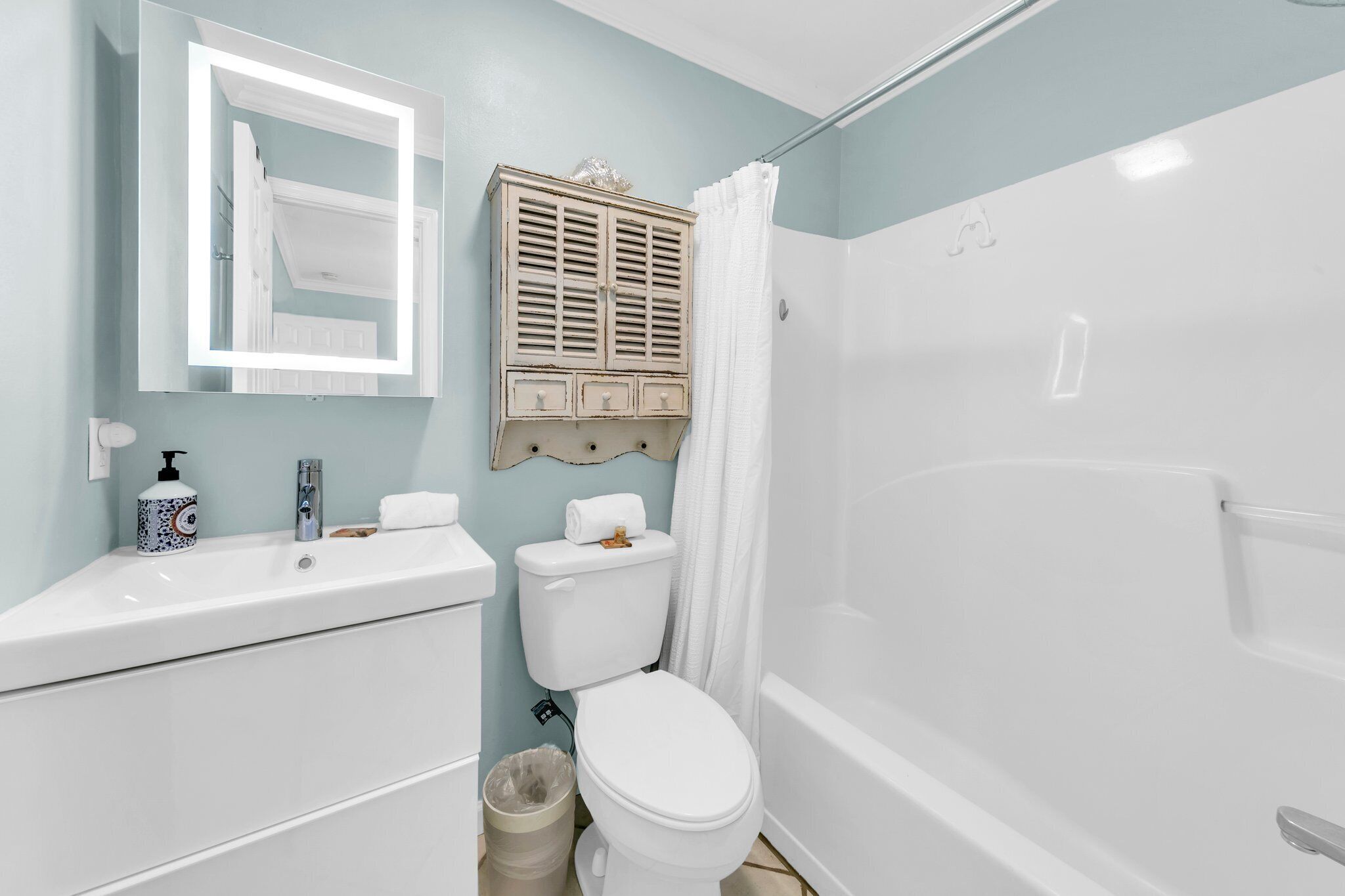 A bathroom with a white sink, toilet, and bathtub.