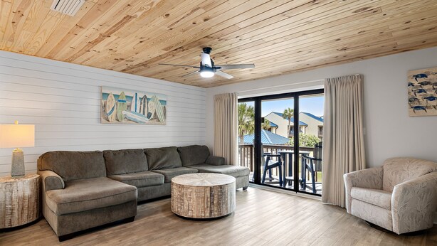 A living room with a wooden ceiling, a sofa, a round coffee table, and a chair. - 🐾️Pet Friendly ~ Beach View - Pool ~ Blue Surf 22☀️ (Miramar Beach)