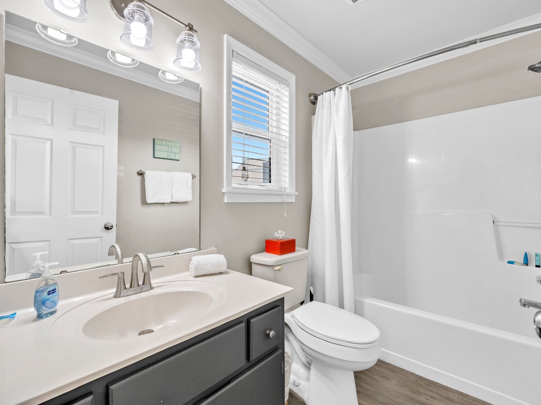 A bathroom with a white sink, a toilet, and a shower area.
