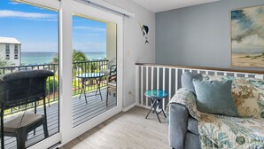 A balcony with a view of the ocean, a dining area with chairs and a table, and a living area with a sofa and cushions. - ⭐Beach Views -Gated Community Pool - Balconies-2BR Gulf Winds East #3 ⭐ (Miramar Beach)