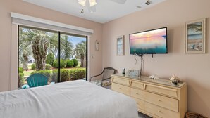 A bedroom with a bed, a dresser, a TV, and a view of the outdoors. - ⭐Beach Views -Gated Community Pool - Balconies-2BR Gulf Winds East #3 ⭐ (Miramar Beach)