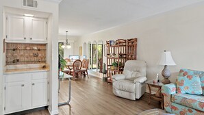 Un salón amplio con sofá, sillón y comedor.