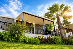 A modern house with a covered porch, a palm tree, and lush greenery. - PALM BEACH ŞİLE (Sile)