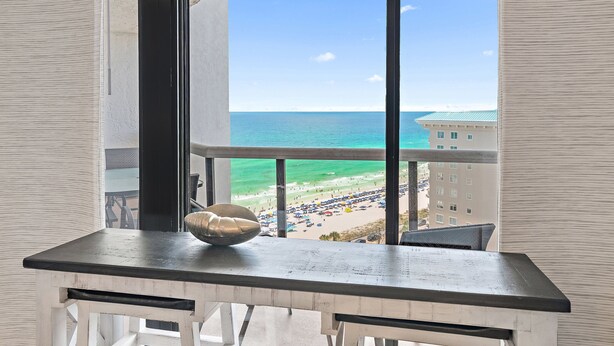 A balcony with a view of the beach and ocean.