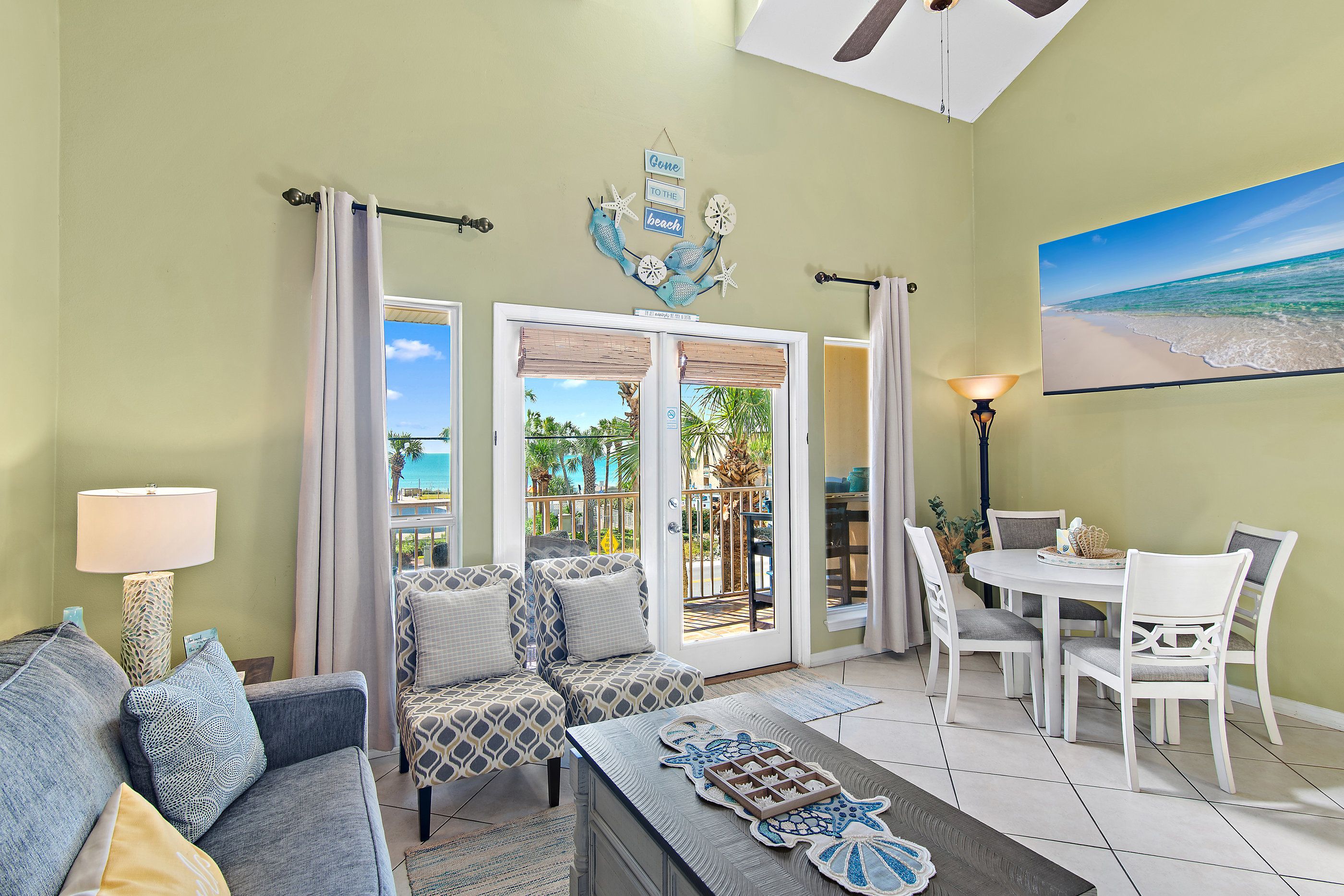 Une chambre d’hôtel avec vue sur la plage, un coin repas et un espace salon avec des meubles à motifs.