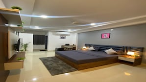 A modern bedroom with a large bed, bedside tables, a desk, and a TV. - Housr 78 Madhapur Hyderabad Hitech City (Hyderabad)