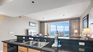 A modern kitchen with a double sink, wooden cabinets, and a view of the ocean. - ☀️By Beach in Seascape-16th FL Gulf Views-3 Pools-Ariel Dunes II 1606☀️ (Miramar Beach)