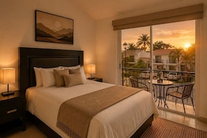 A hotel room with a bed, bedside lamps, a painting, and a balcony with a table and chairs.
