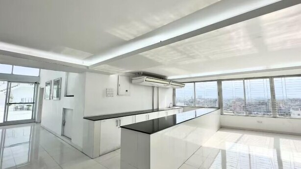Una cocina moderna con una isla central, ventanas amplias y vistas a la ciudad.