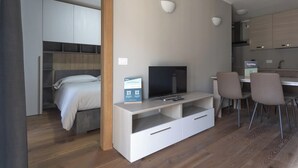Un appartamento moderno con una camera da letto, un'area pranzo e una cucina.