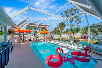 Soak up the sun in this vibrant, screened-in oasis! Heated pool, fun floats, colorful umbrellas, and total privacy perfect for your next getaway. 