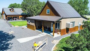 A large barn-style building with a covered porch and a gravel driveway.