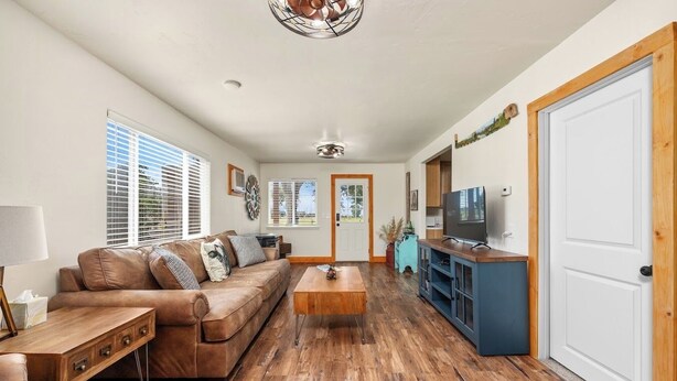 A living room with a brown leather sofa, wooden coffee table, and a TV on a blue cabinet.