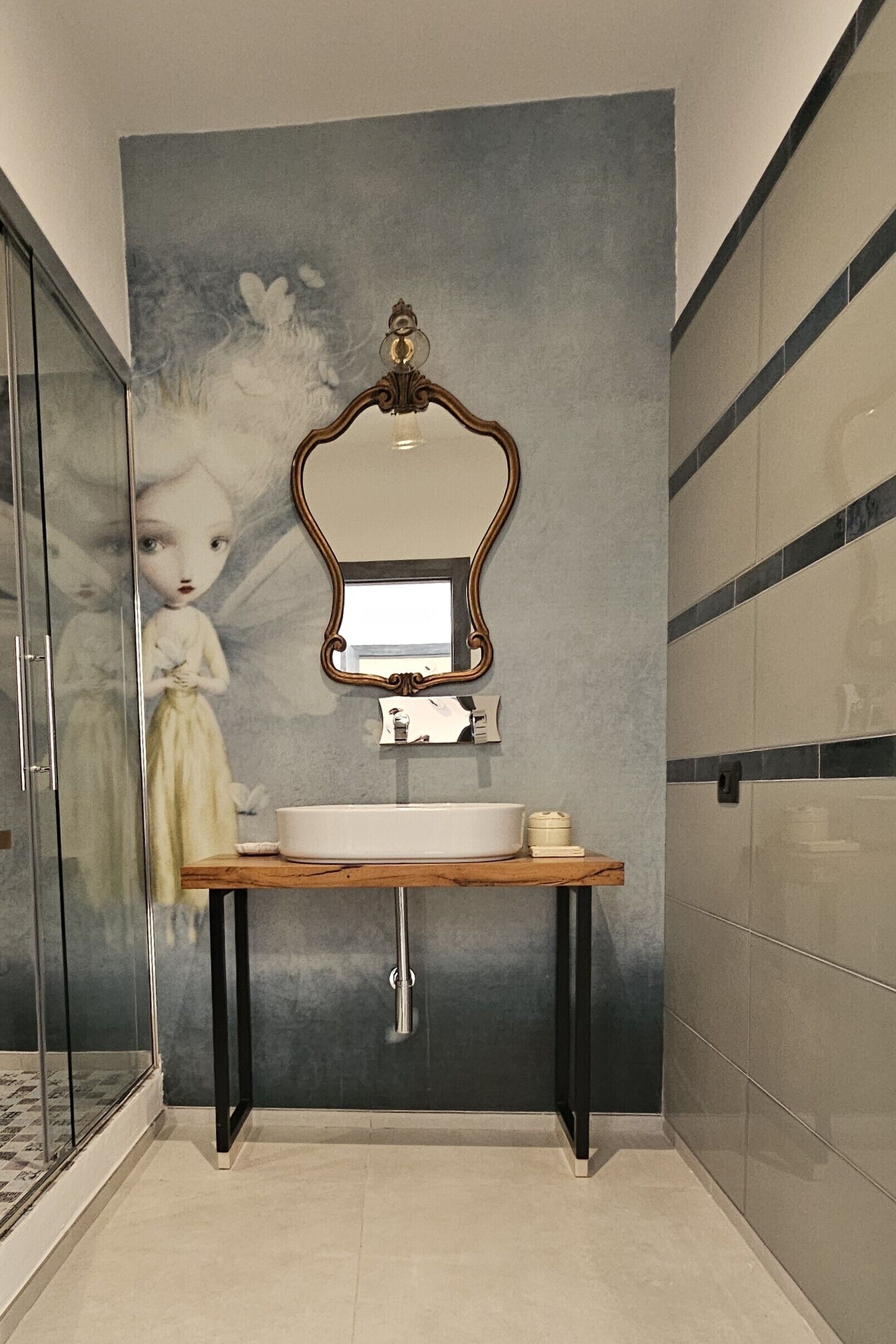 Ein Badezimmer mit großem Spiegel, Waschbecken und einem dekorativen Wandbild.