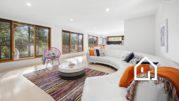 A modern living room with a white sofa, a round coffee table, and a colorful rug. There are large windows providing natural light and views of the outdoors. - Lookout & Sea *1 NIGHT FREE* Beachfront Bliss in McCrae (McCrae)
